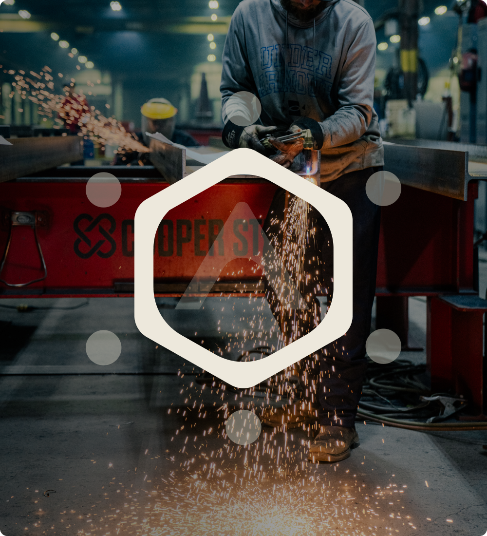 Worker grinding metal with sparks, geometric logo overlay in foreground.
