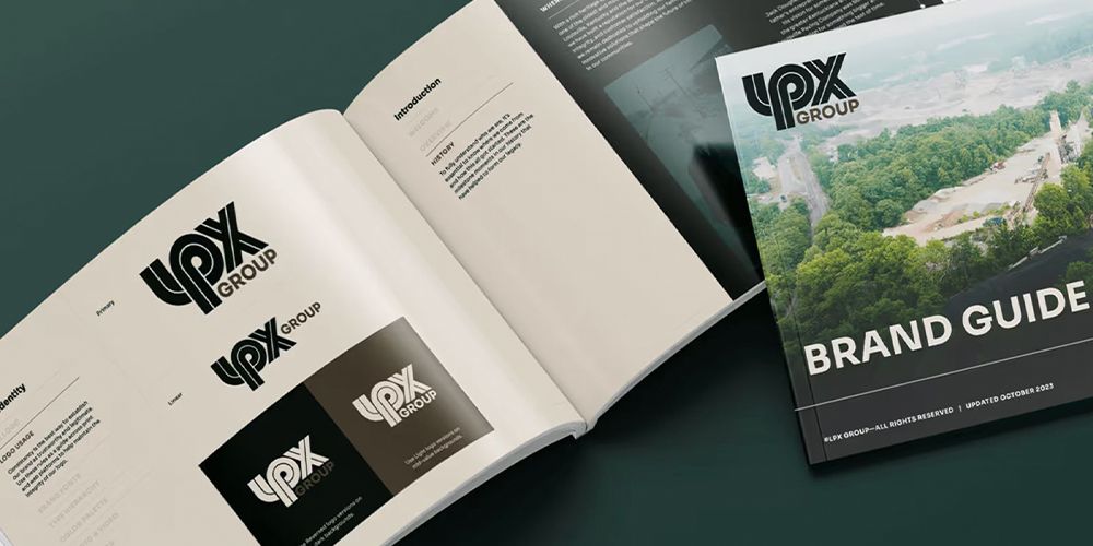 UPX Group brand guide booklets on dark green, showing logos.