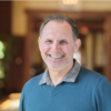 Man in a blue shirt smiling for a headshot