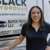 Woman smiling in front of a work truck