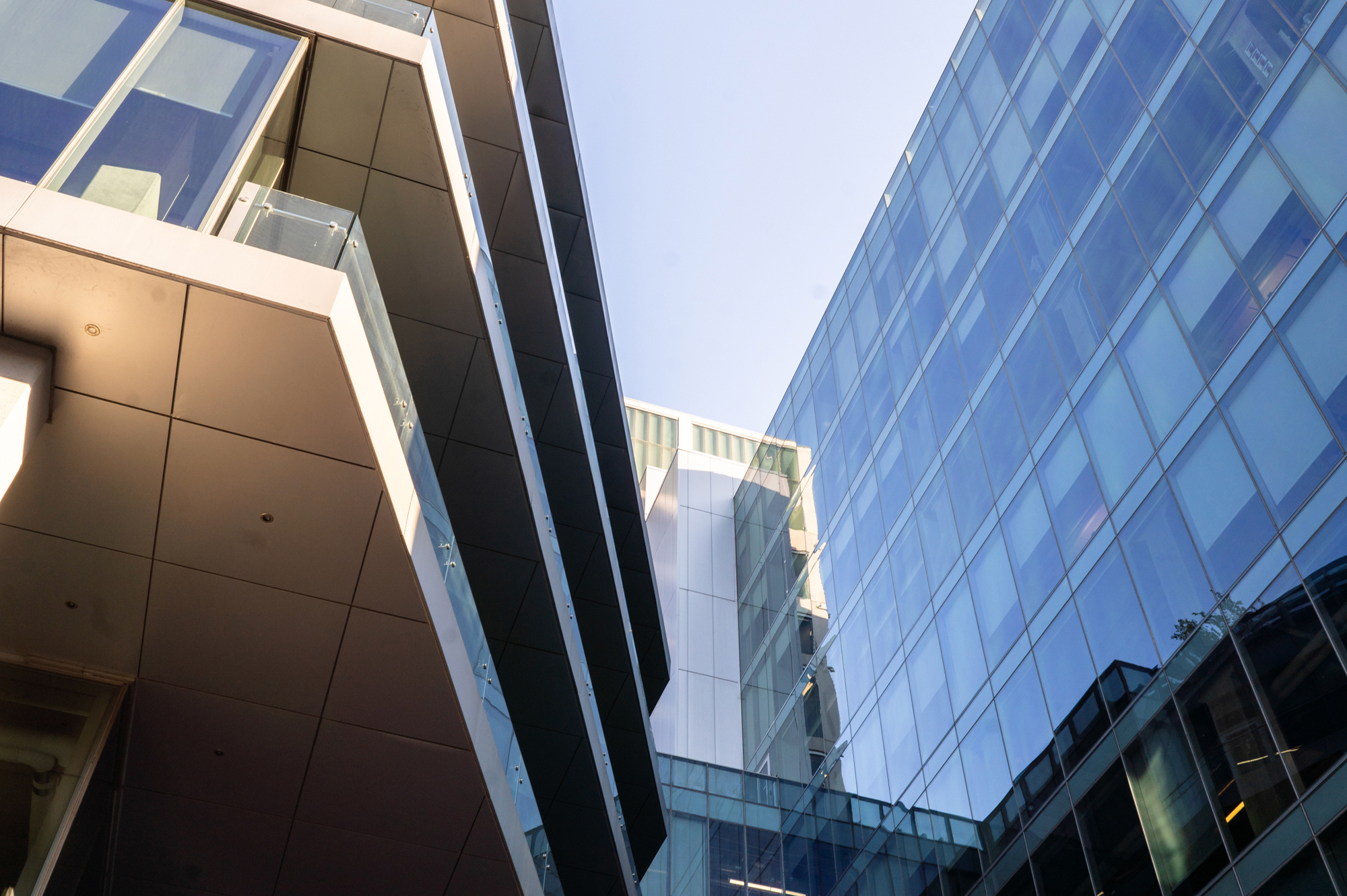 Glass office towers with reflective windows against clear blue sky.