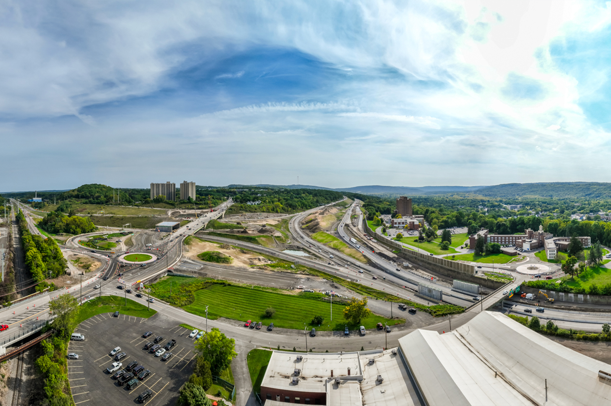 Aerial view of highway interchange construction with roundabout and roads.