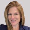 Smiling professional woman in front of a gray background.