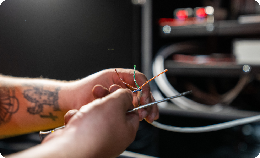 Person's hands working on wiring for a security system.