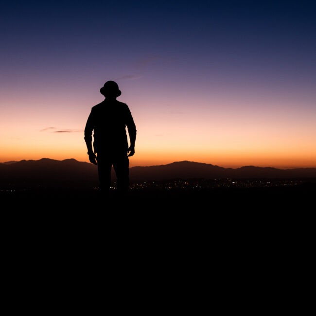 Construction worker silhouetted in a sunset.